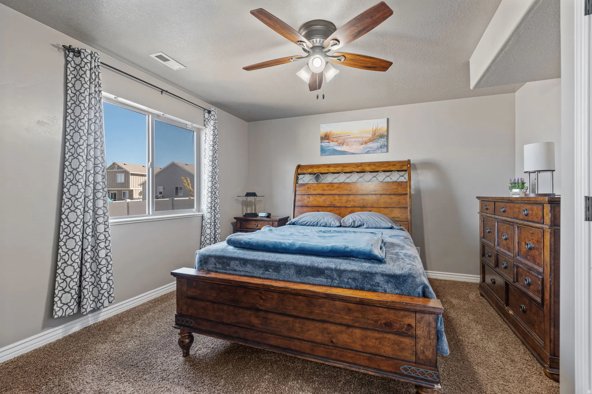 Spacious room with carpeted flooring, a large window, and a ceiling fan with integrated lighting