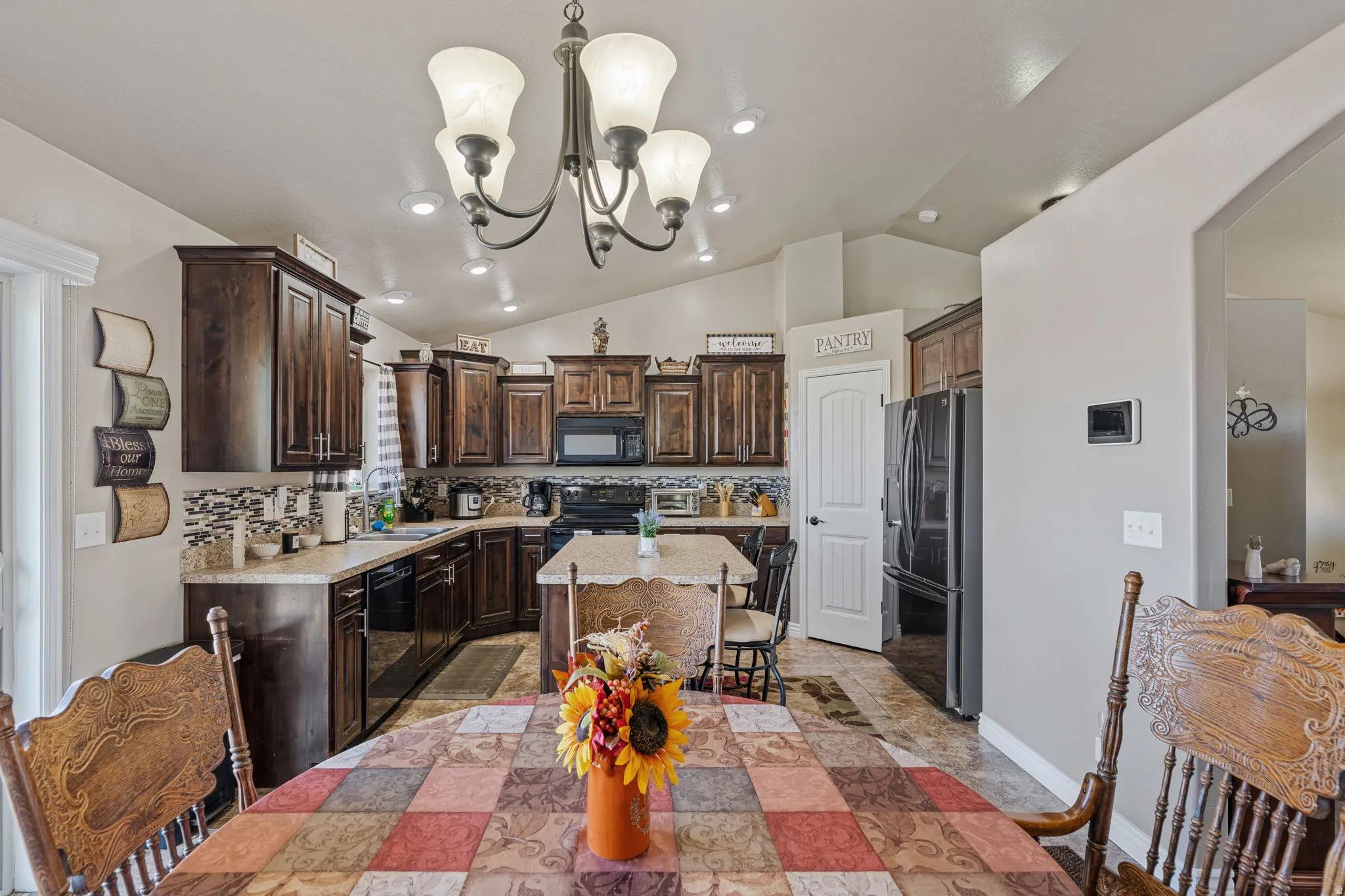 Kitchen featuring dark wood cabinetry, light countertops, mosaic tile backsplash, and a central island