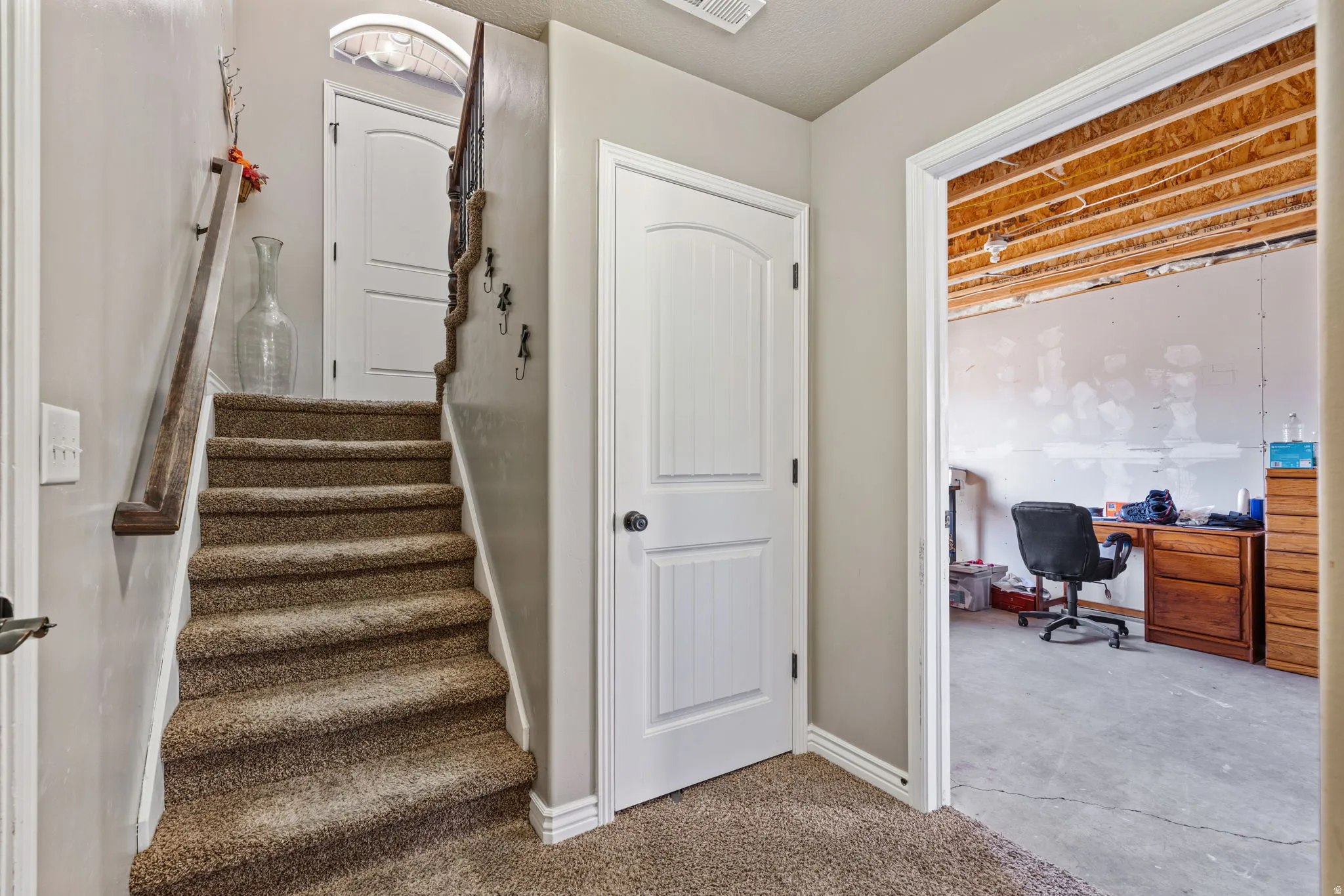 Carpeted staircase with a wood-finish handrail