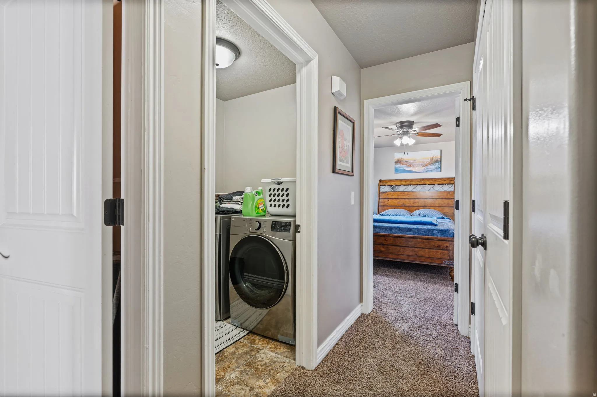 Compact laundry area with built-in shelving and tile flooring