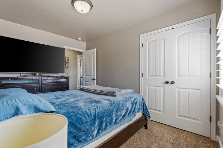 Recessed lighting, neutral wall tones, textured carpeting, white plantation shutters, and white paneled bi-fold doors