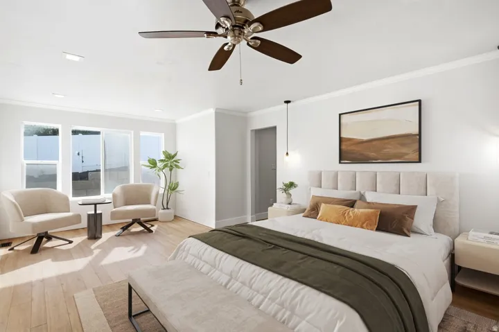Light wood-finish flooring, white walls, and a multi-pane window with white trim