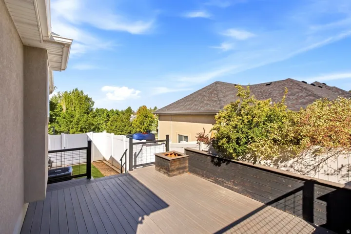 Spacious outdoor deck with composite decking, dark wood-finish railing, and a built-in fire pit