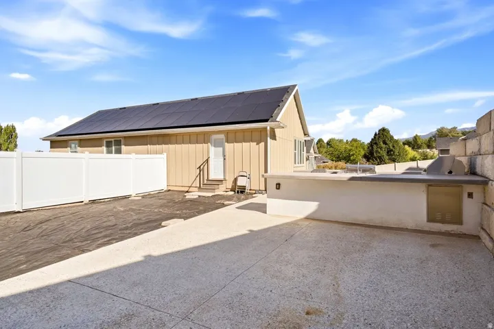 Concrete patio with built-in outdoor kitchen, integrated grill, and stainless steel cabinetry