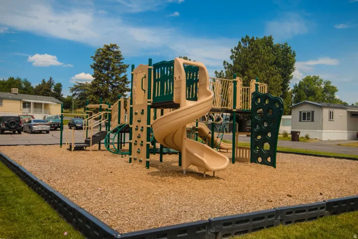 Community playground featuring a multi-level play structure with slides and climbing elements