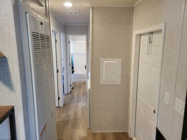 Hallway featuring wood-finish flooring, recessed lighting, white panel doors, and neutral wall finishes