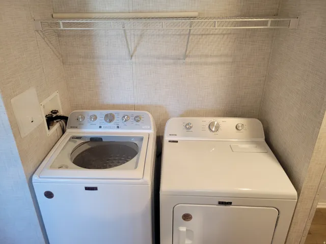 Laundry area featuring textured wall finish and a wire shelving unit with a hanging rod