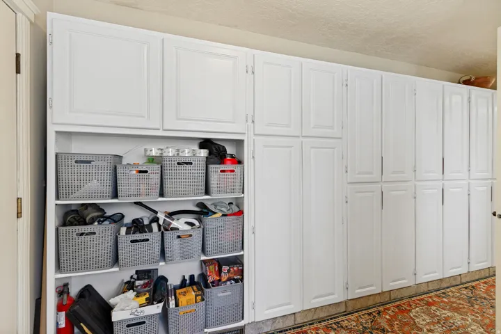 Extensive custom cabinetry with closed storage and open shelving next to kitchen