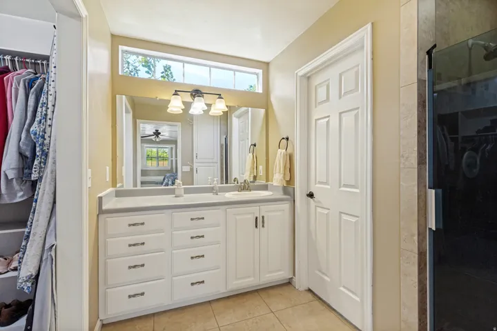 Vanity with integrated sink, extensive countertop space, multiple drawers and cabinet storage, and an elongated mirror