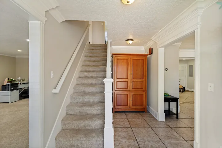 Staircase with carpeted treads and white wood-finish railing