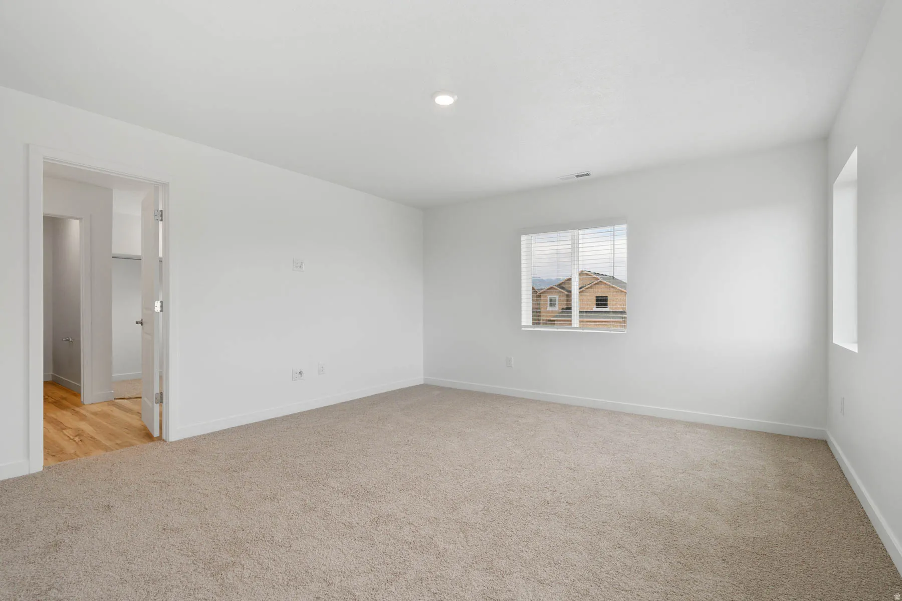 Neutral-toned carpeting with white wall paint
