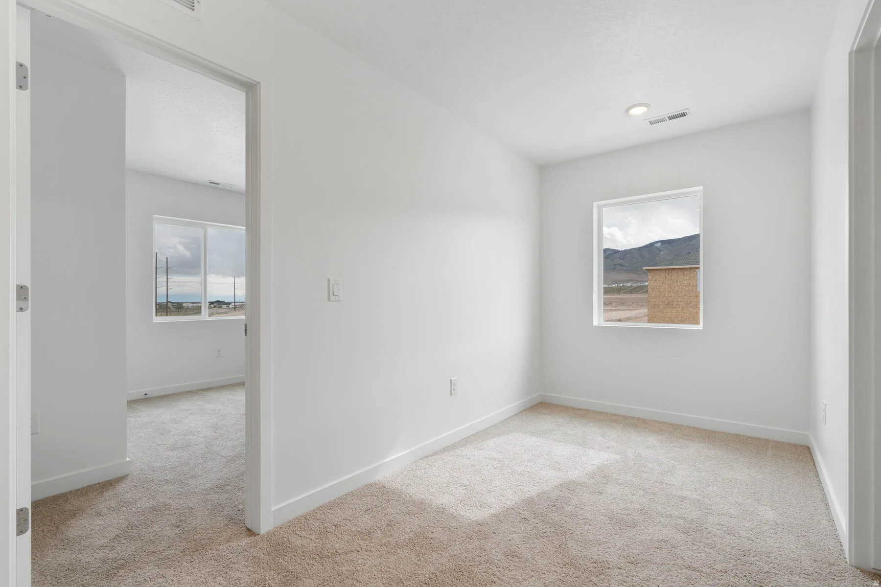 Carpeted room with white walls, a single window, and recessed lighting