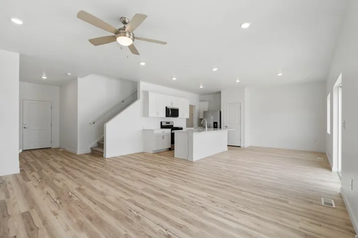 Open-concept living space featuring wood-finish flooring, recessed lighting, and a modern ceiling fan