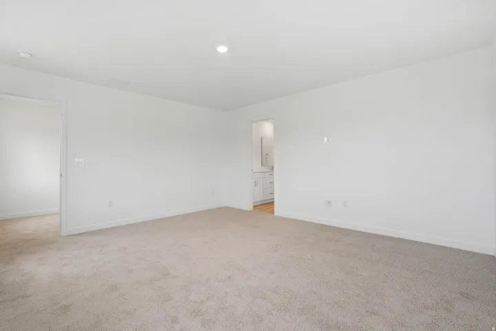 Spacious interior with neutral carpeting and a smooth ceiling