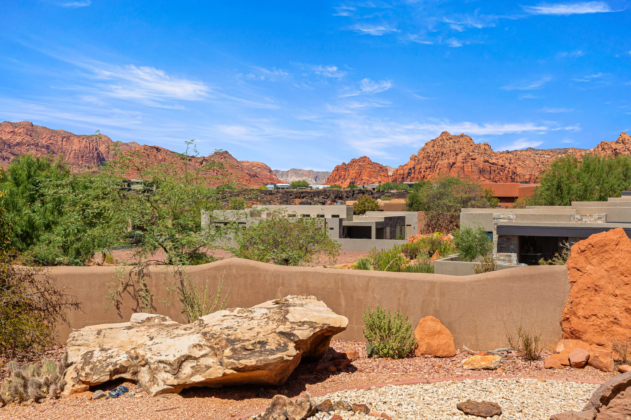 Elevated desert landscaping featuring natural rock formations and a gravel ground cover