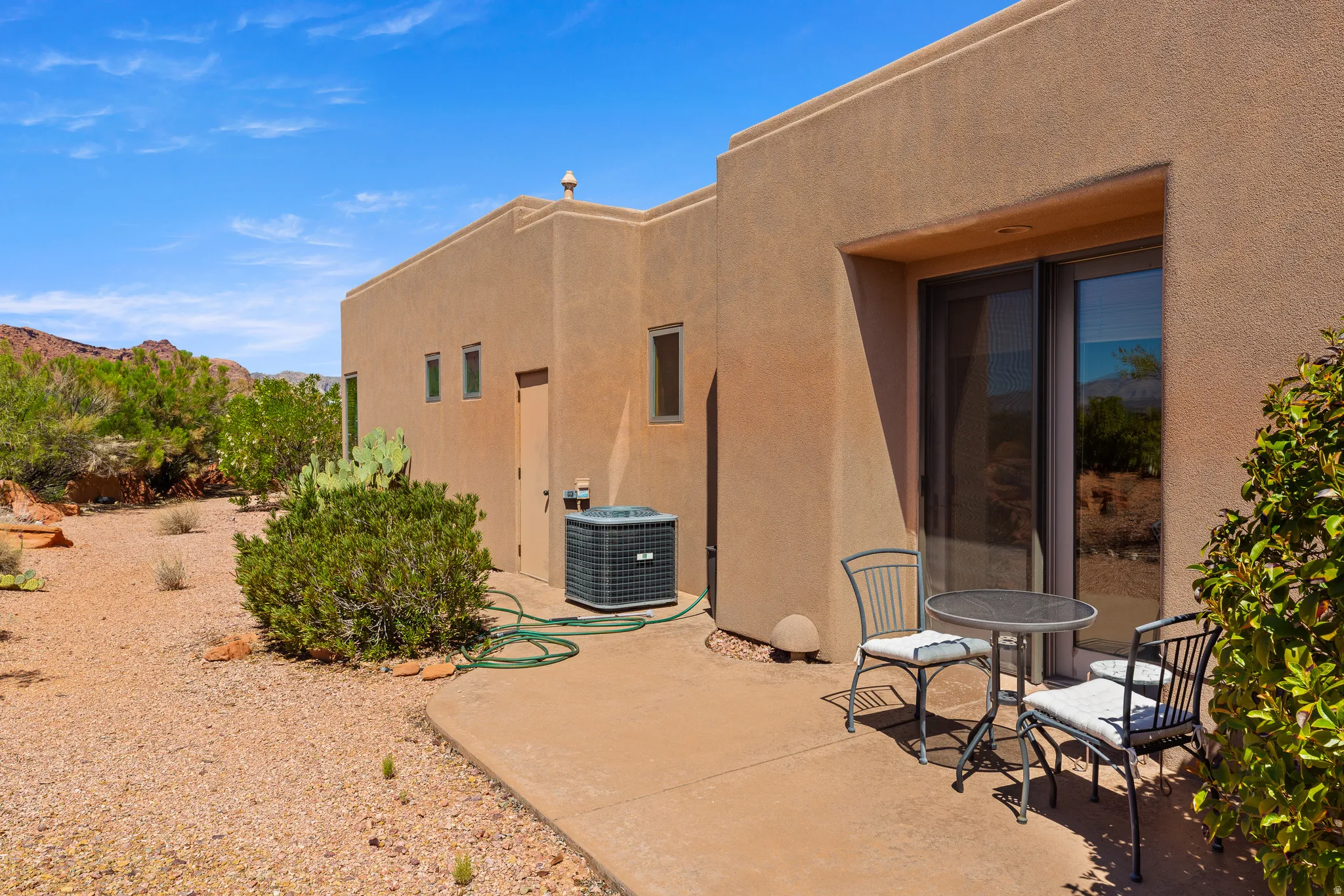 Stucco exterior with a concrete patio and desert landscaping
