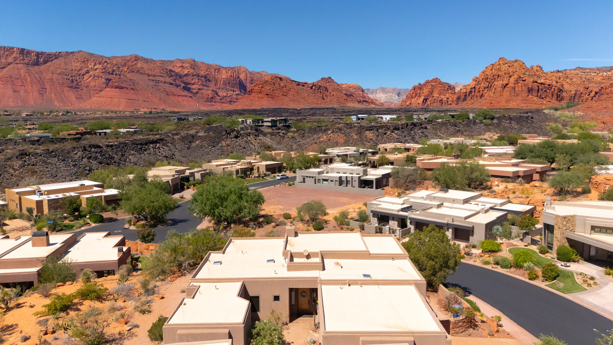 Desert landscape featuring extensive red rock formations and multiple residential properties