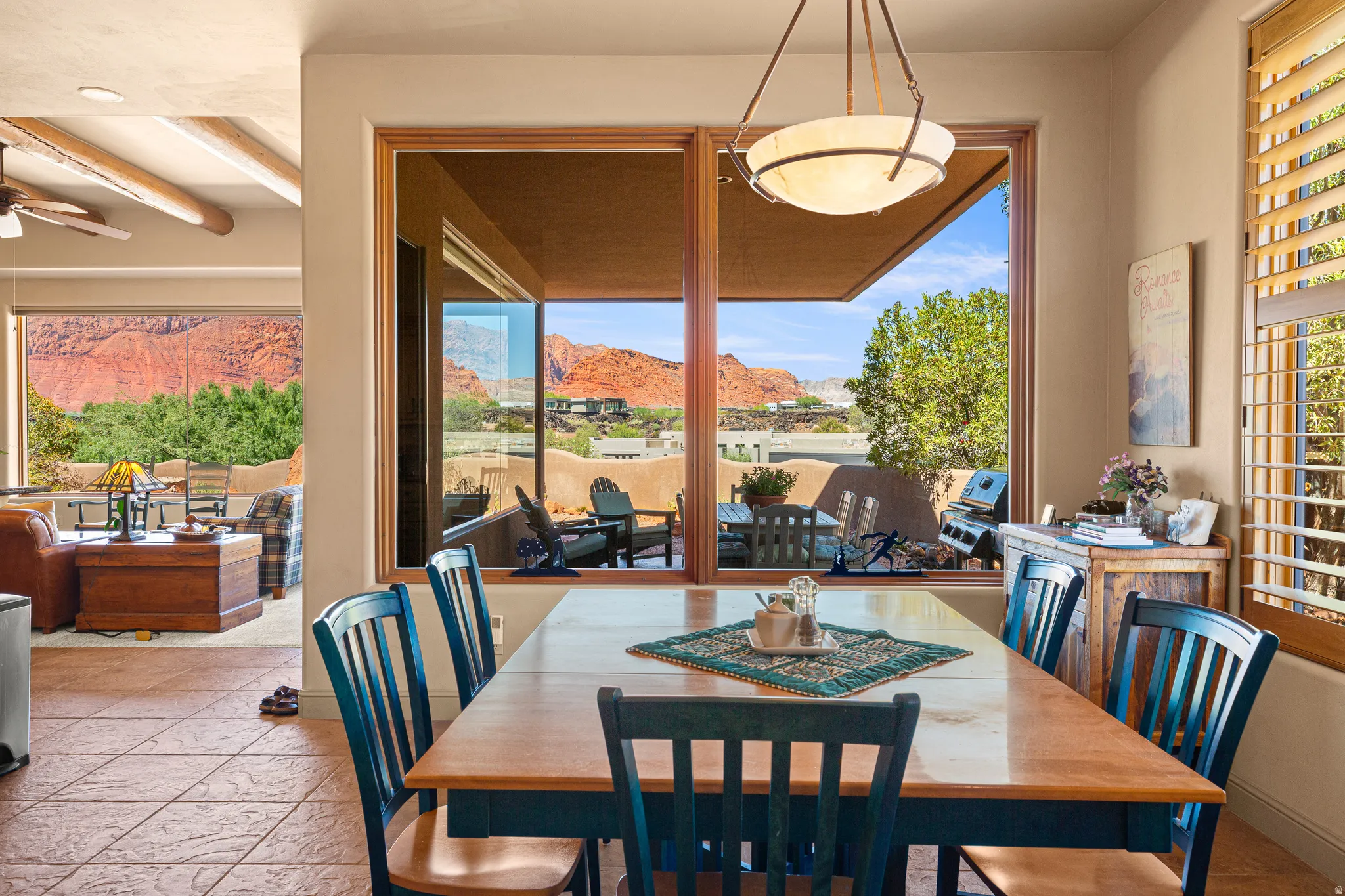 Expansive windows with red rock scenery, tile flooring, and wood-finish window frames