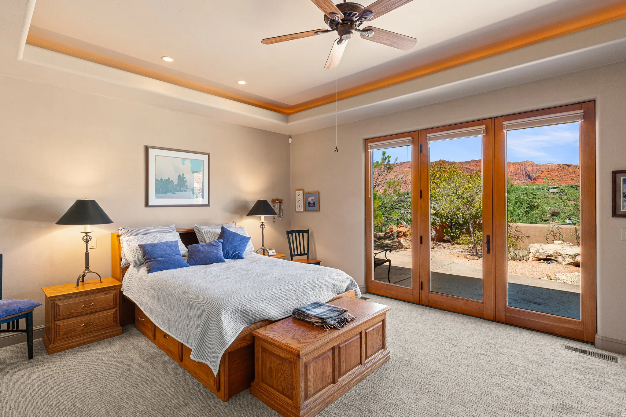 Tray ceiling with recessed lighting, ceiling fan, carpeted flooring, French doors, and natural wood trim
