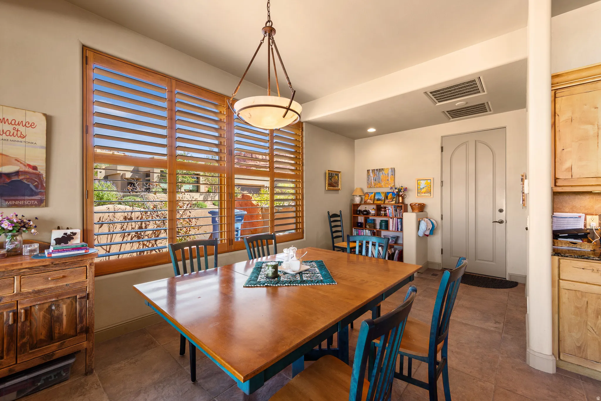 Wood-finish plantation shutters, tile flooring, built-in cabinetry, and a ceiling-mounted light fixture