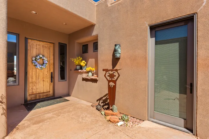 Stucco exterior with a solid wood entry door, adjacent sidelight windows, and a recessed entryway