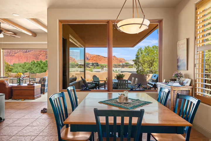 Expansive windows with red rock scenery, tile flooring, and wood-finish window frames