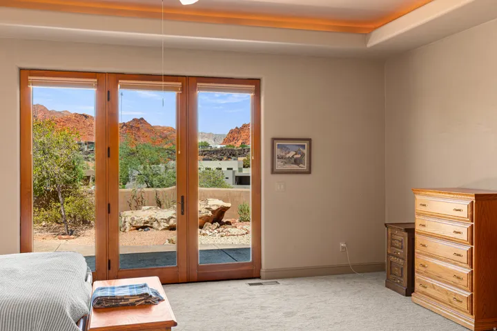 Three-panel glass door with wood frames, tray ceiling with cove lighting, and neutral wall tones