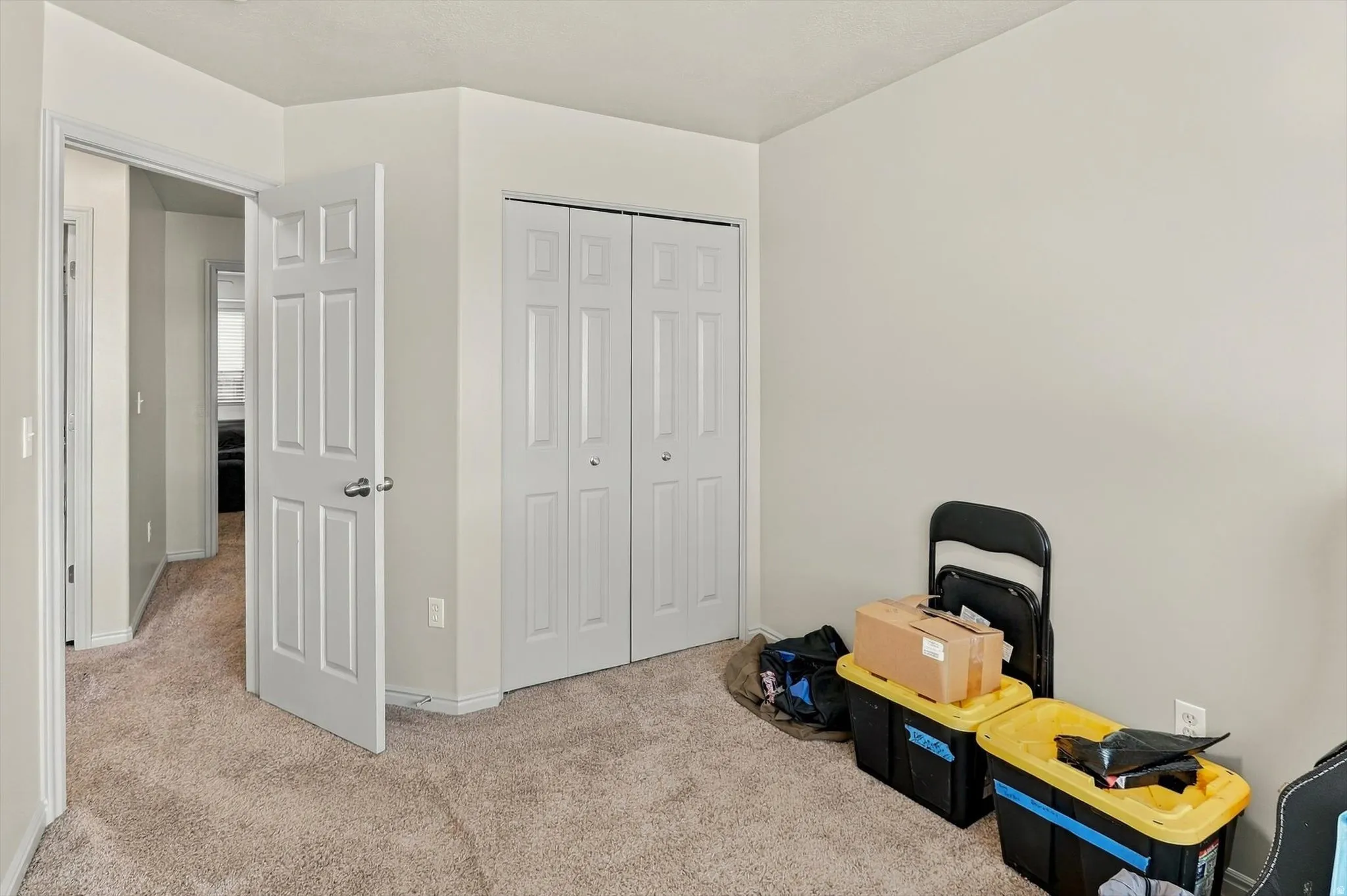 Neutral tone wall paint, carpeted flooring, built-in bi-fold closet, and classic panel doors
