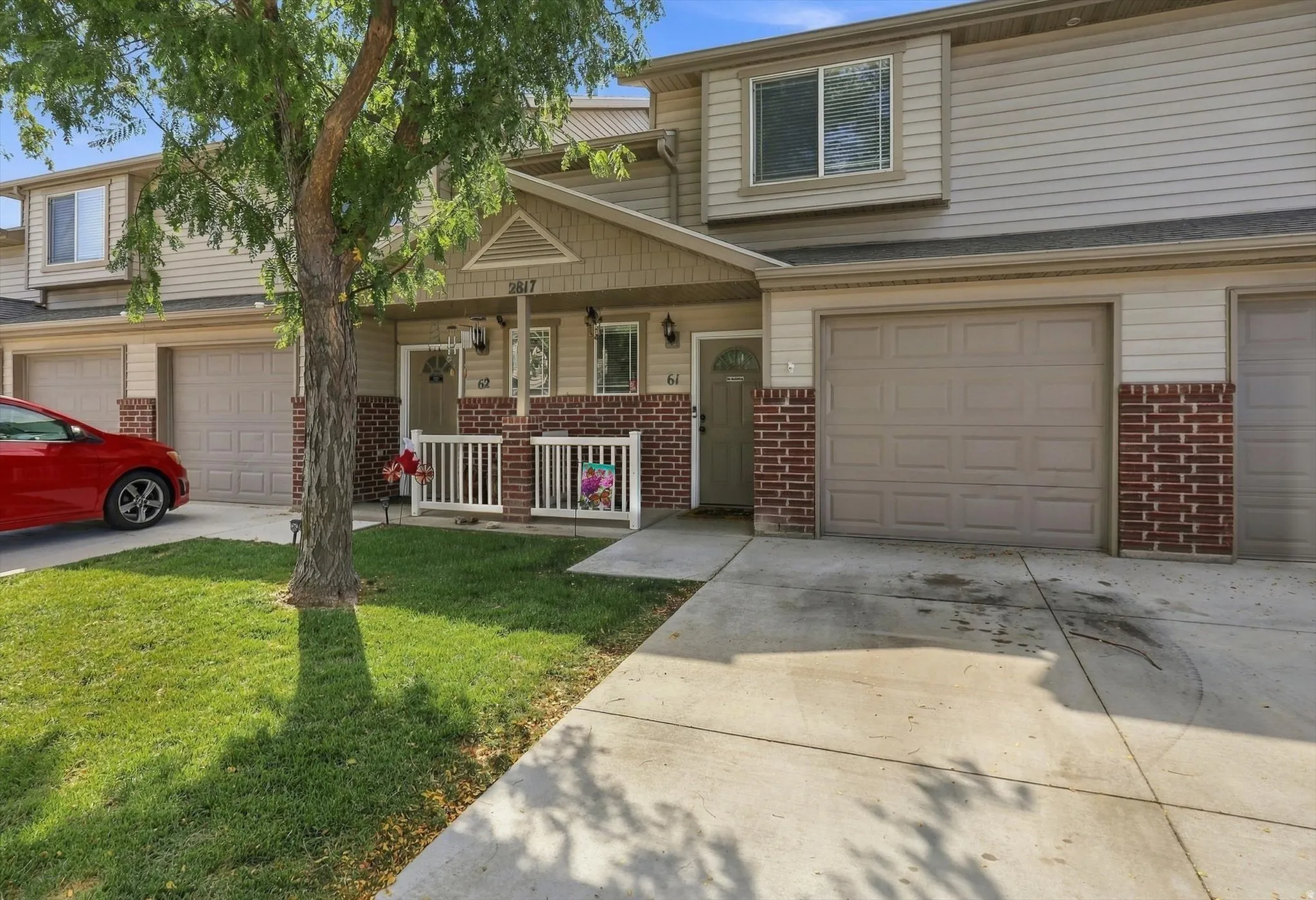 Townhome exterior featuring siding, brick accents, and a covered porch with white railing
