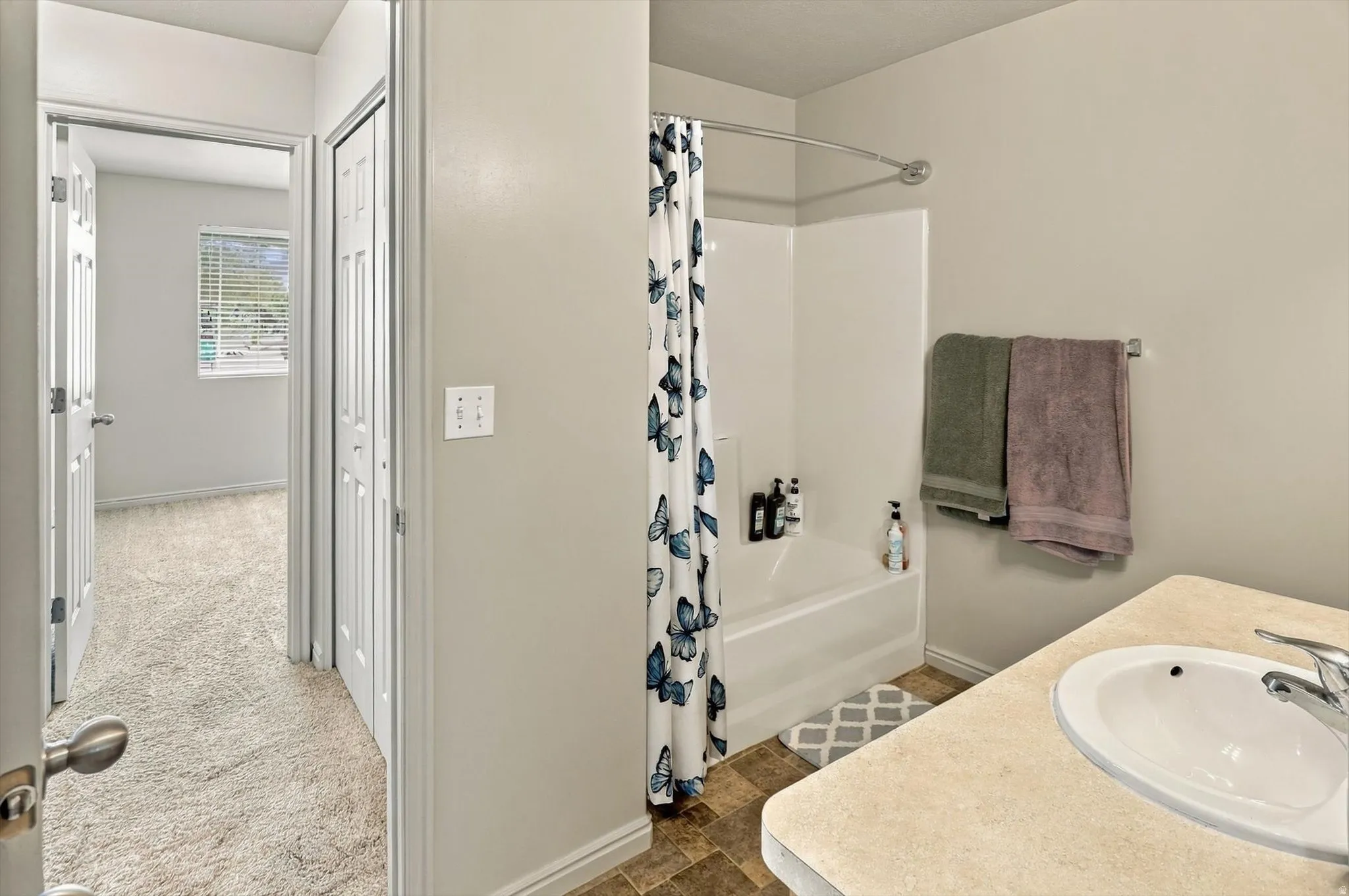 Bathroom featuring a built-in vanity with an integrated sink and a shower-over-tub combination