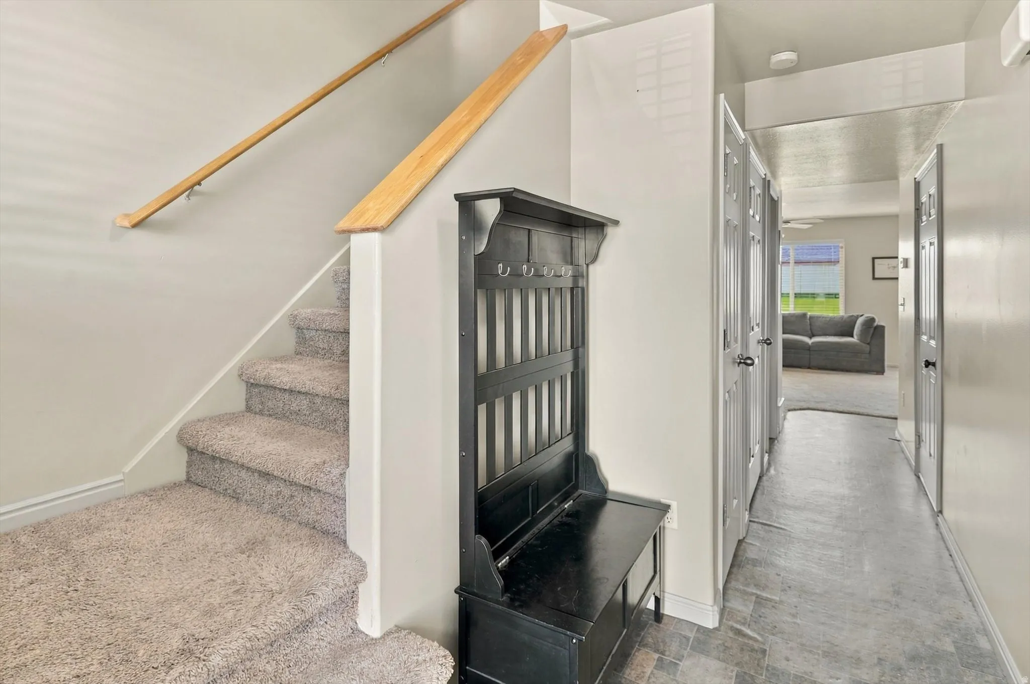 Carpeted staircase with wooden handrails