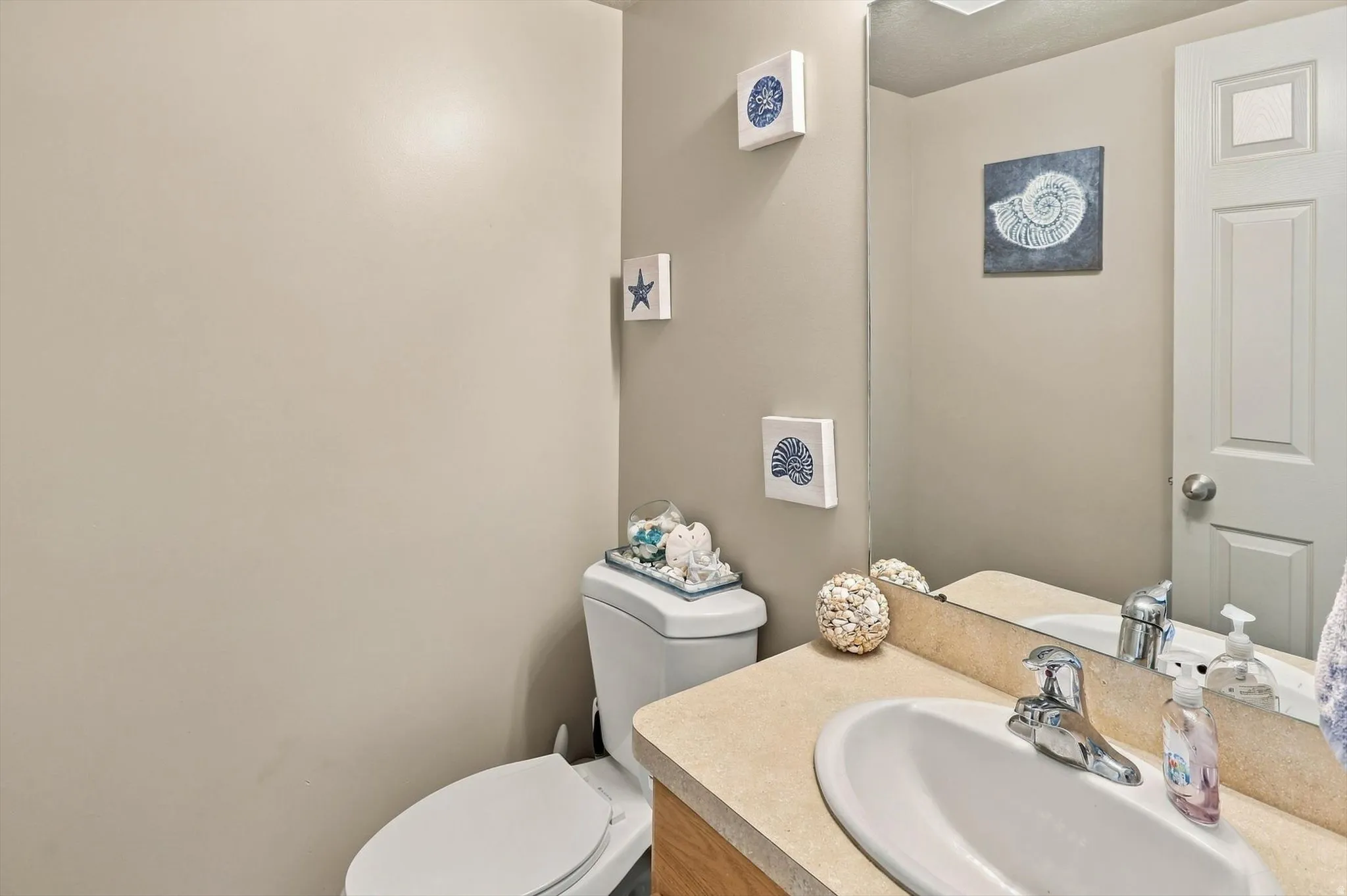 Built-in vanity with a light-colored countertop, undermount sink, and chrome faucet