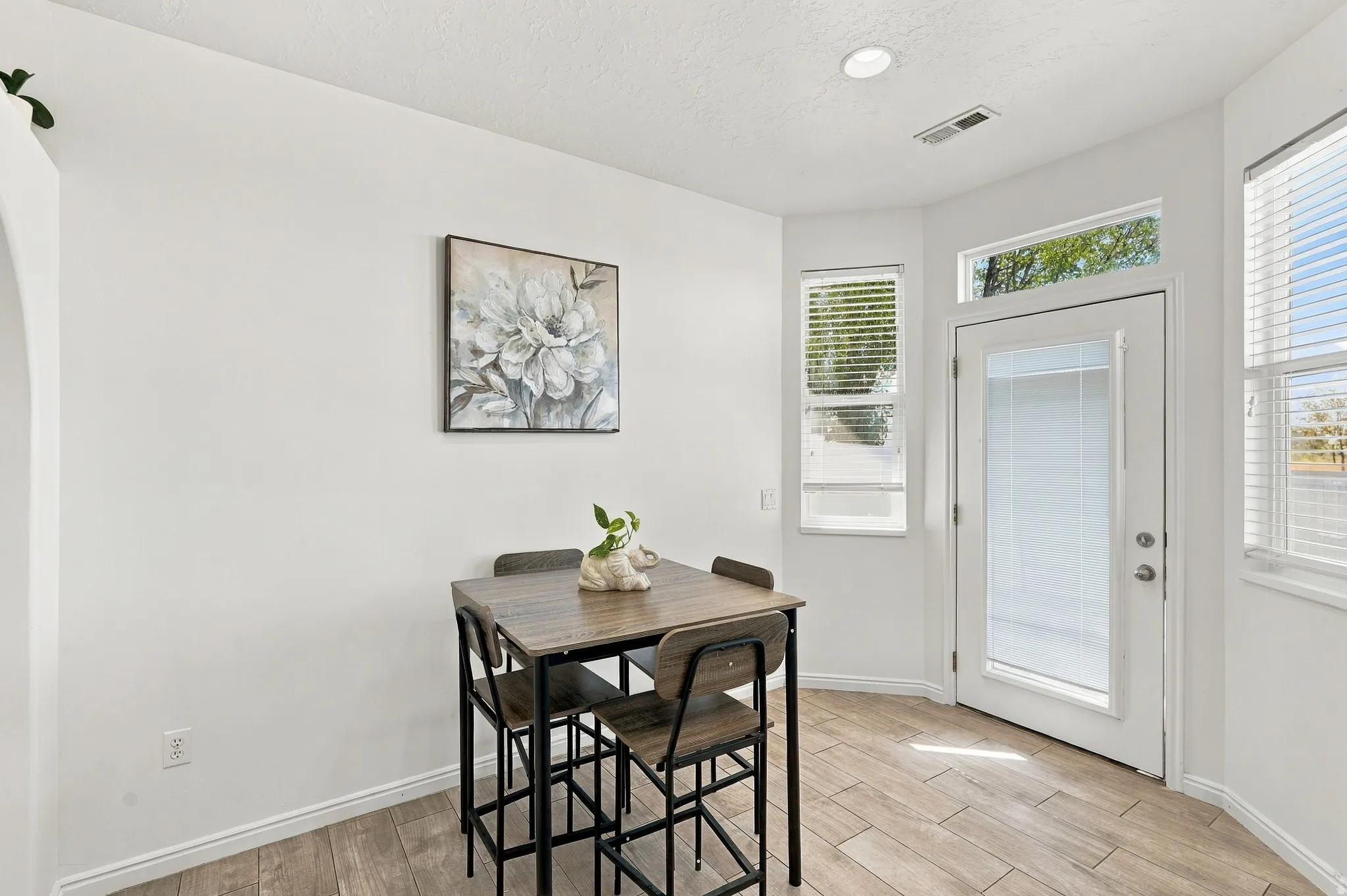 Wood-finish tile flooring, recessed lighting, and white walls with a curved archway