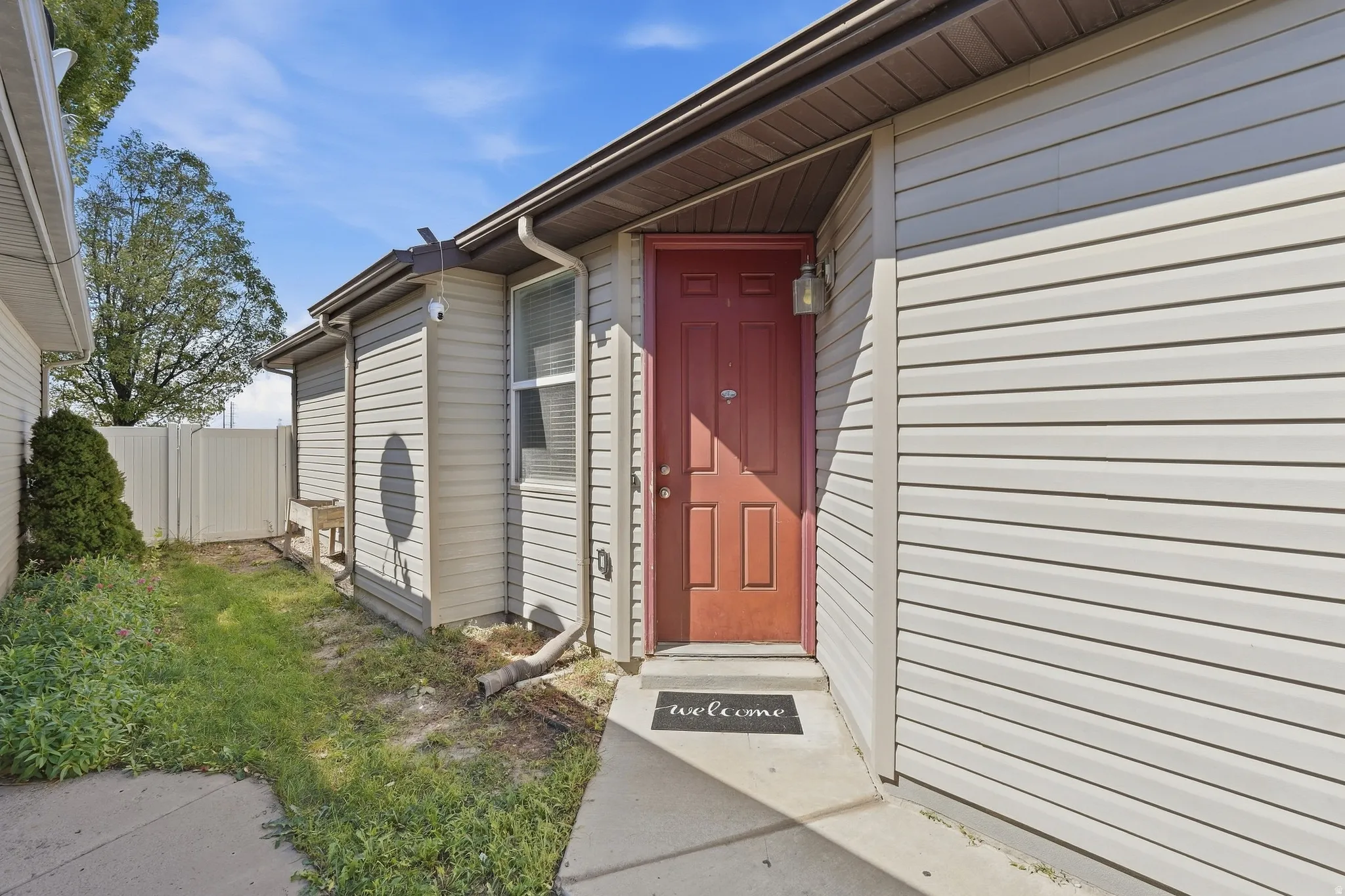 Beige horizontal siding with a red paneled entry door