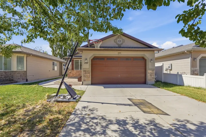 Stucco and stone facade with an arched entry, a two-car garage with a wood-finish door, and a concrete driveway