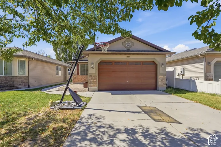Stucco and stone facade with an arched entry, a two-car garage with a wood-finish door, and a concrete driveway