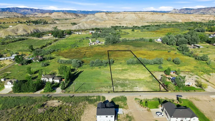 Expansive lot featuring open green space and a distant mountain backdrop