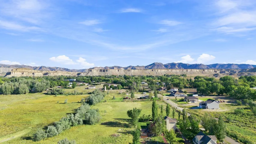Expansive green spaces and mature trees complemented by distant mountain ranges