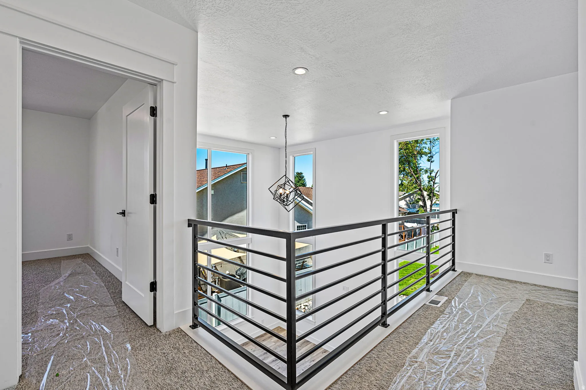 Modern interior railing, recessed lighting, and a contemporary pendant light fixture