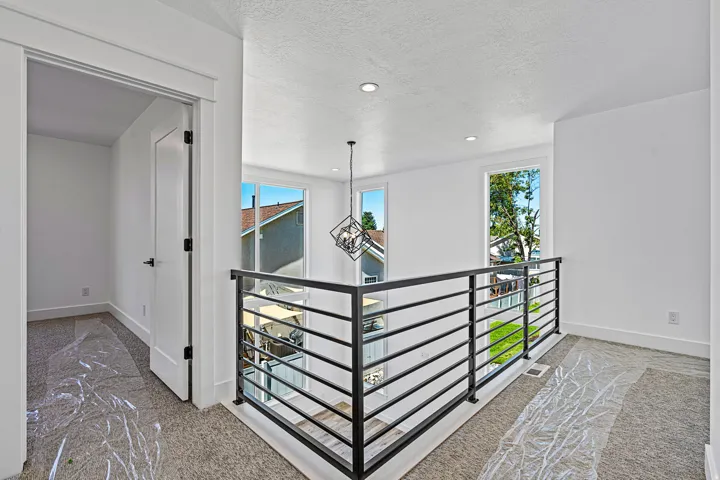 Modern interior railing, recessed lighting, and a contemporary pendant light fixture