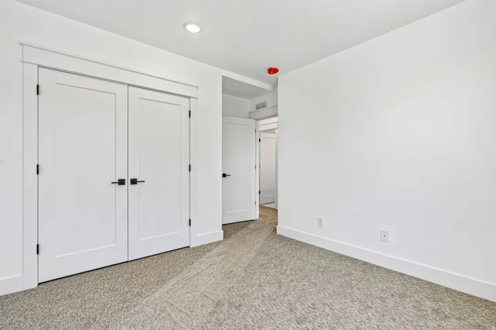 Neutral color palette with textured carpeting, recessed lighting, and white trim