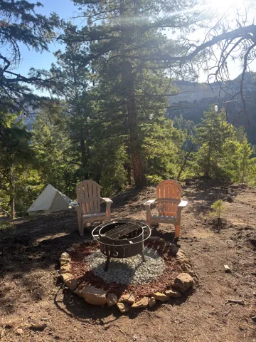 Outdoor fire pit with a gravel and mulch base, surrounded by natural stone