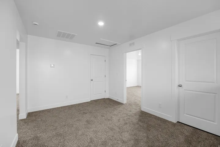 Carpeted flooring, white walls, recessed lighting, and white trim