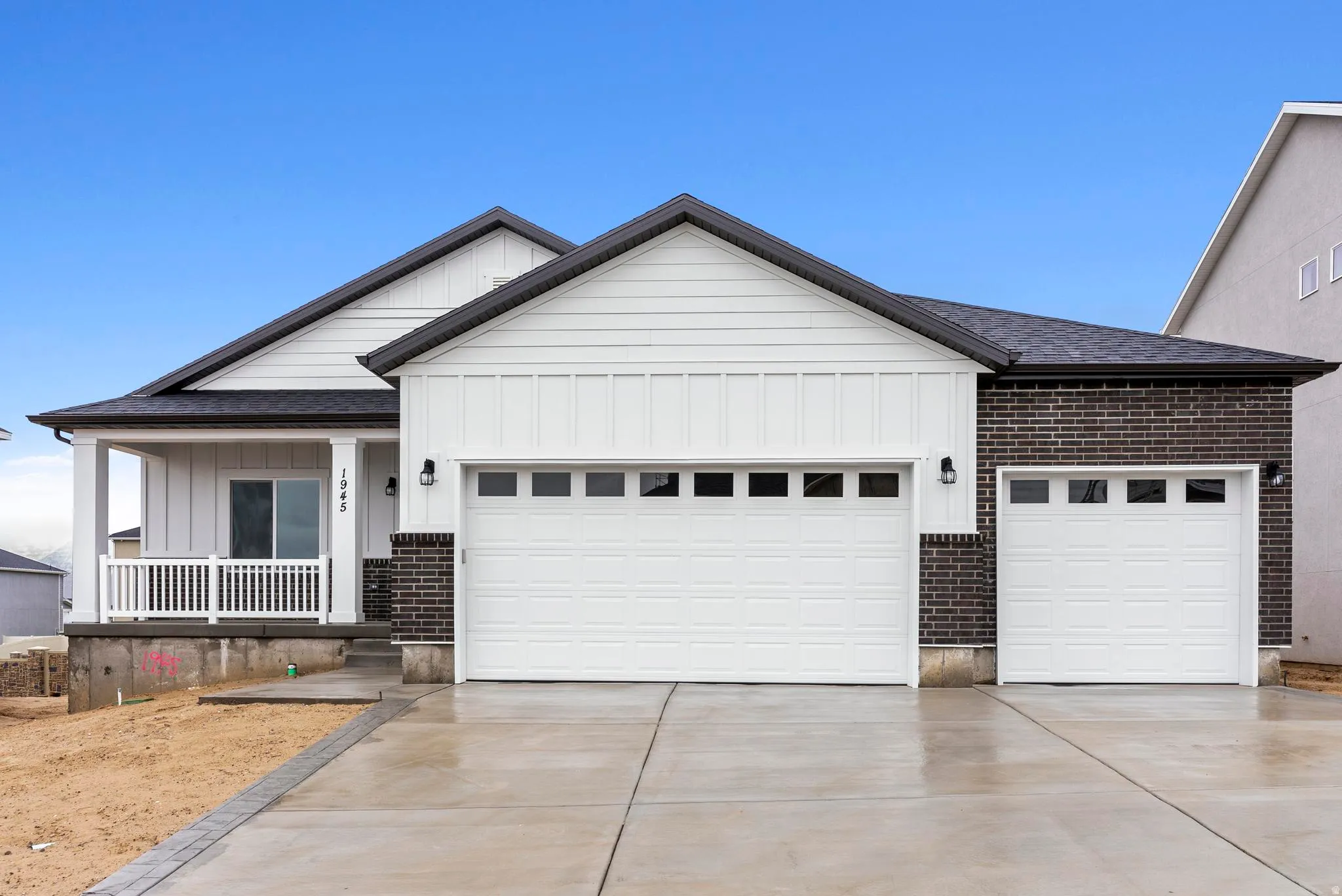 White siding exterior with dark brick accents