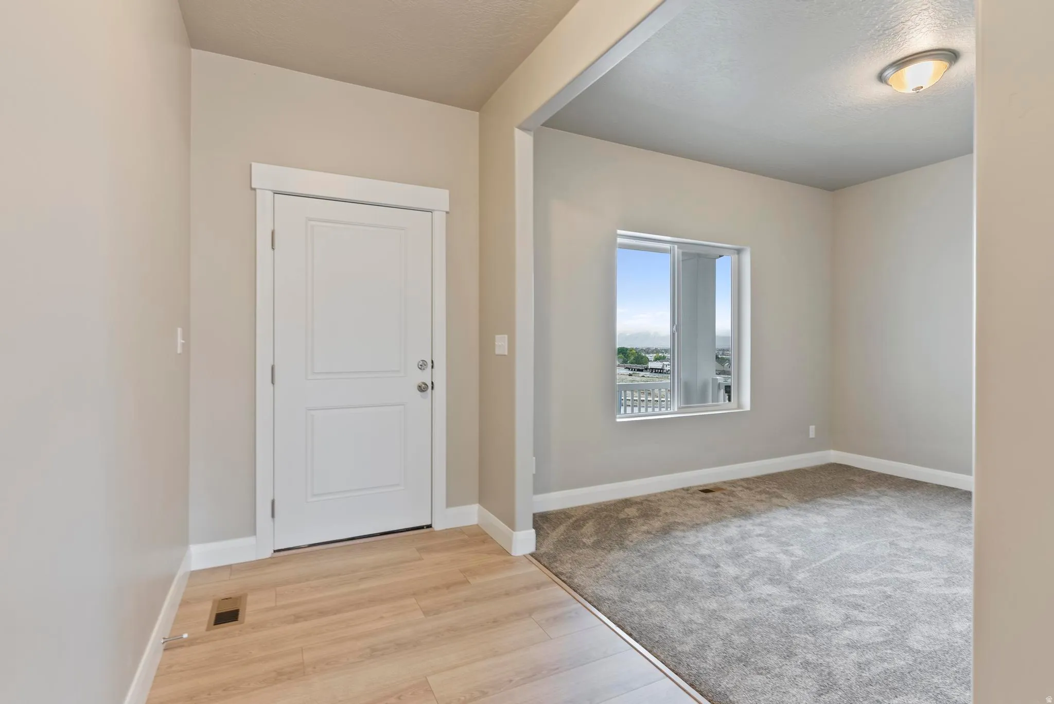 Entryway with wood-finish flooring, a paneled door, and neutral wall tones