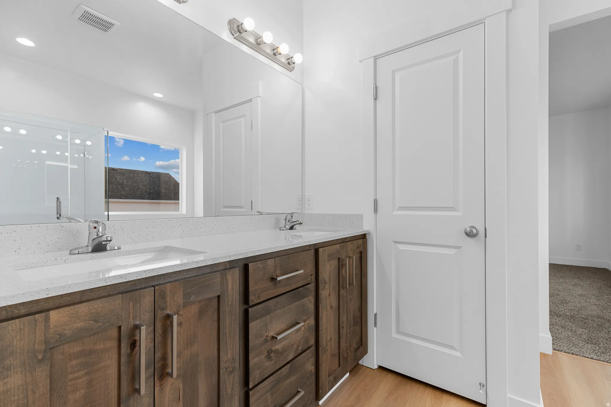 Dual vanity with integrated sinks and a quartz-finish countertop