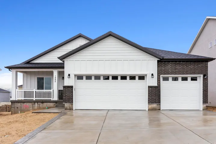 White siding exterior with dark brick accents