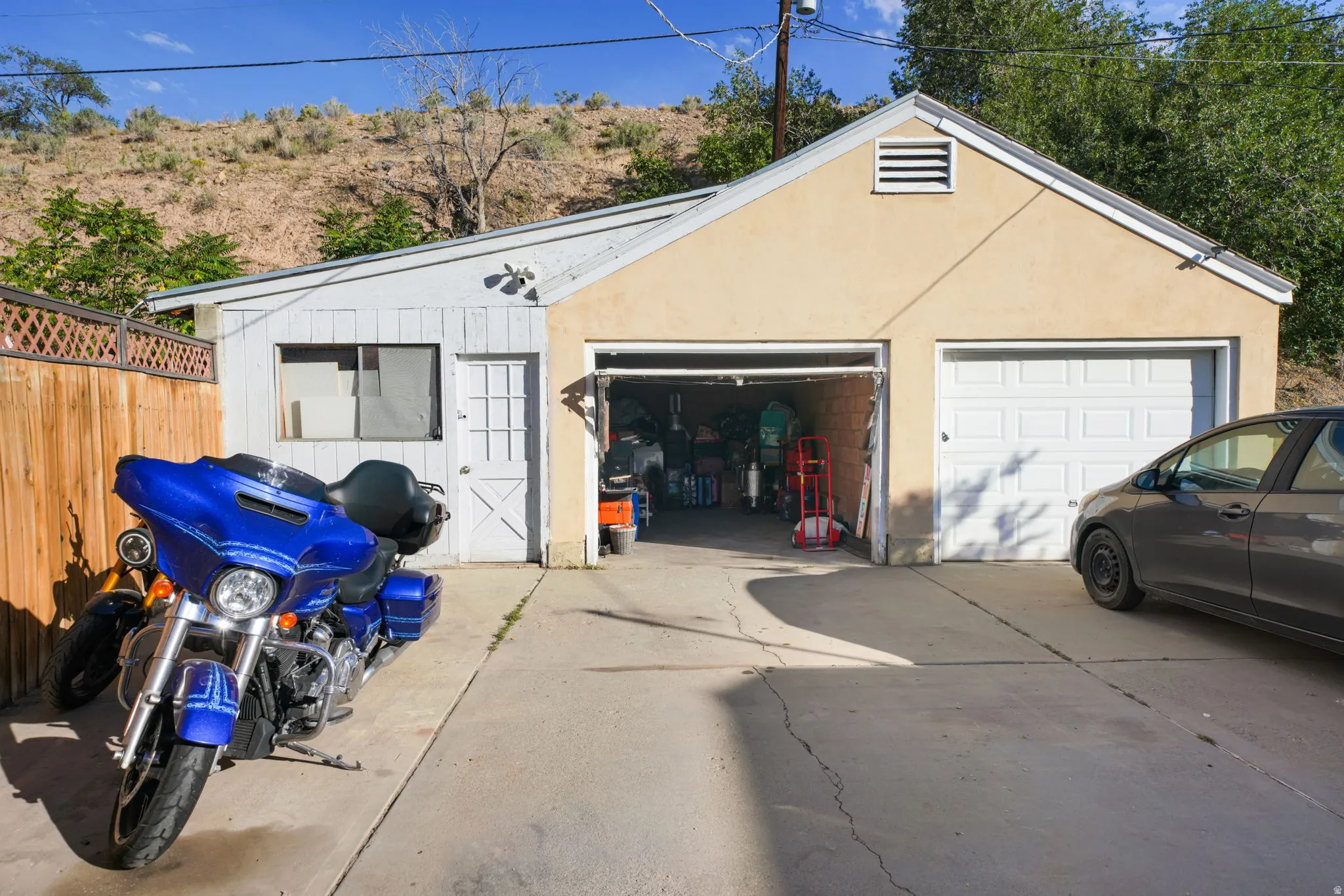 Detached garage with two bays, one open and one with a white panel door