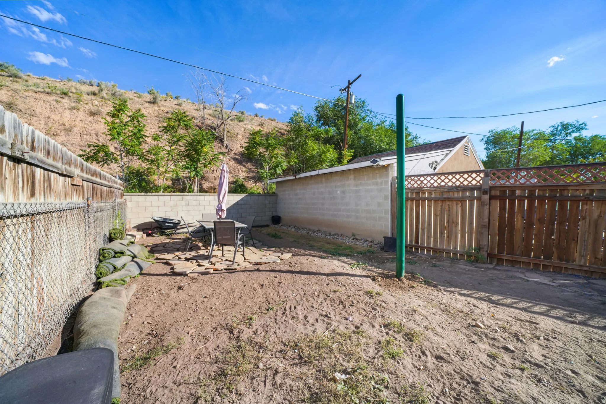 Private outdoor space featuring a paved patio area, wood fencing, and concrete block walls