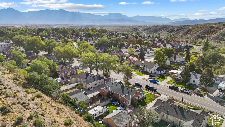 Residential neighborhood with mature trees, paved streets, and a mountainous backdrop